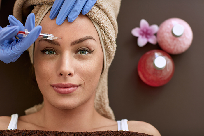 woman receiving forehead injections