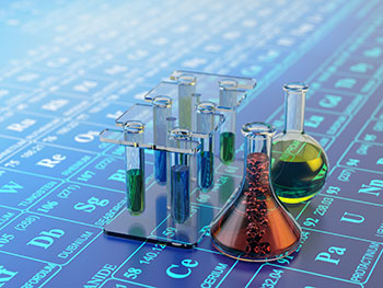 Chemicals in beakers on top of the periodic table